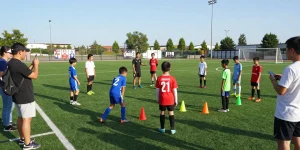 More from our blog on community soccer initiatives, featuring diverse young players practicing on a sunny field.